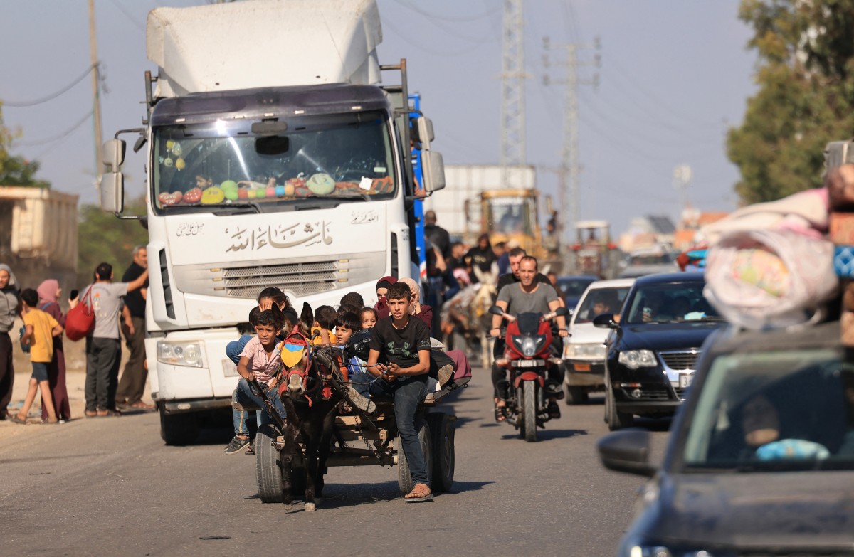 Riding a donkey drawn cart as family along with hundreds of other Palestinian carrying their belongings flee following the Israeli army's warning to leave their homes and move south before an expected ground offensive, in Gaza City on October 13, 2023. (File/AFP)