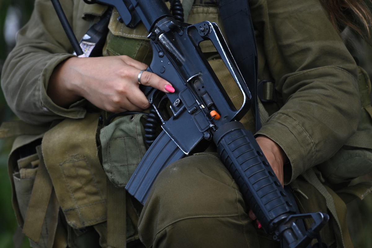 An Israeli soldier stands guard in Kibbutz Beeri near the border with the Gaza Strip on October 15, 2023. (AFP)