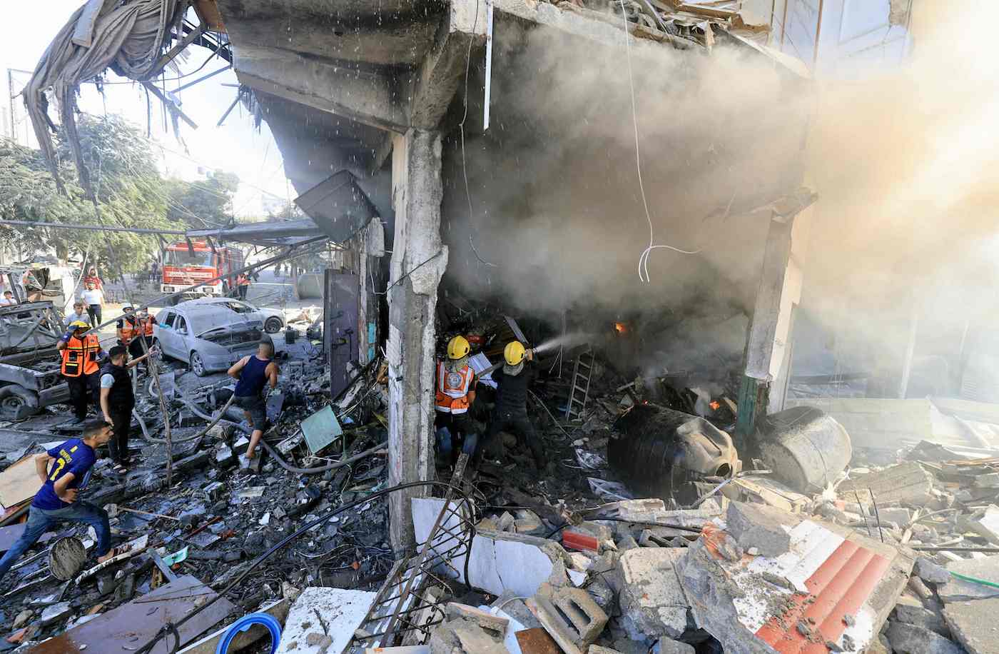 Palestinian rescuers douse a fire at the scene of an Israeli strike in Khan Yunis in the southern Gaza Strip on October 17, 2023. (AFP)