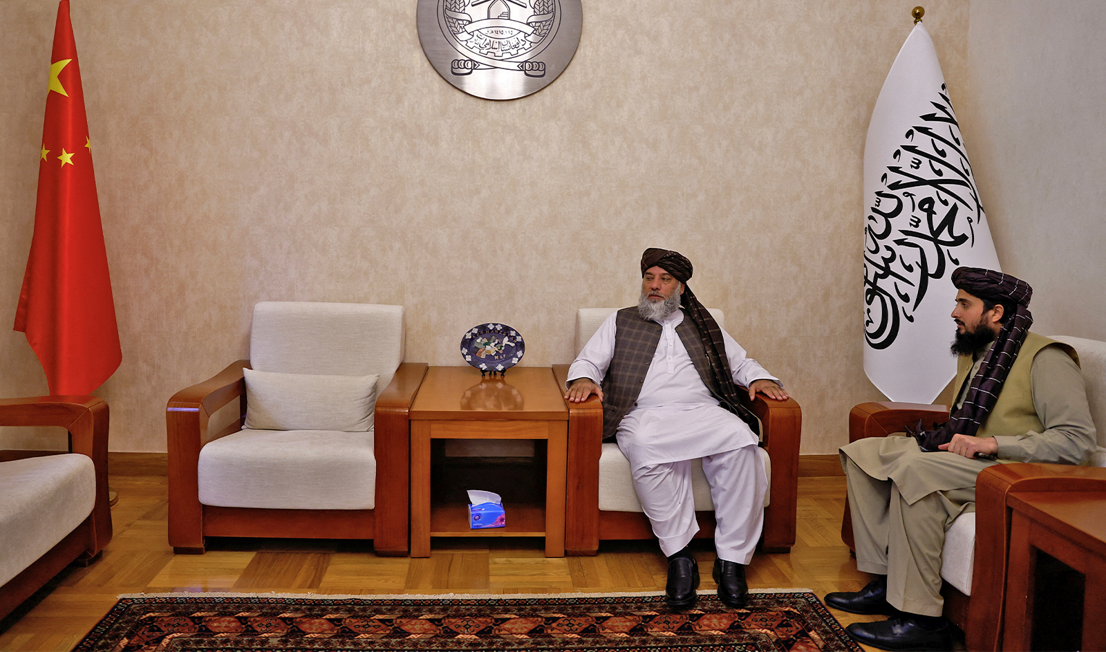 Taliban's acting commerce minister Haji Nooruddin Azizi sits next to flags of the Islamic Emirate of Afghanistan and China, during an interview with Reuters, at the Embassy of Afghanistan in Beijing, China on October 19, 2023. (REUTERS)