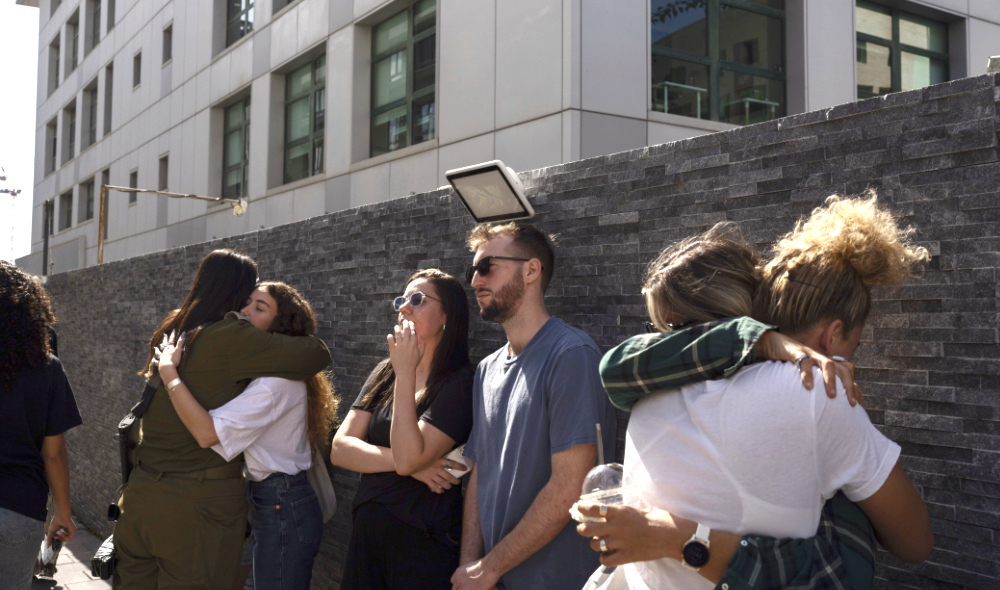 Friends and family members hug each other during a funeral of the Israeli man Ziv Shapira who was killed by Hamas militants, outside a bar in Tel Aviv, Israel. (AP)