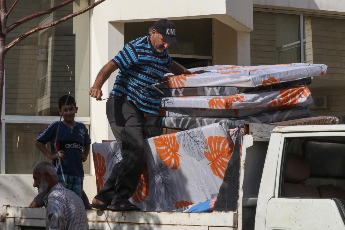 Workers deliver relief supplies to displaced Lebanese families from villages near the southern border who took refuge at a school in Tyre city, as they sought safety further from the intensifying border tensions between Israel and Hezbollah and allied Palestinian factions. (File/AFP)