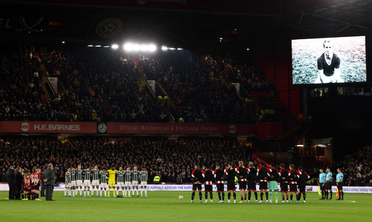 Players pause to remember legendary Man United and England midfielder Bobby Charlton whose death was announced Saturday evening, ahead of the English Premier League football match between Sheffield United and Manchester United at Bramall Lane in Sheffield, northern England. (AFP)
