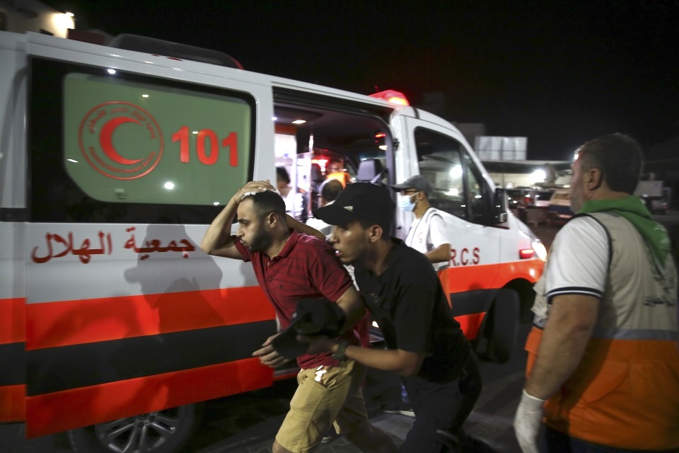 Palestinian medics help a man wounded in Israeli strikes in Gaza City on Oct. 13, 2023. (AP)
