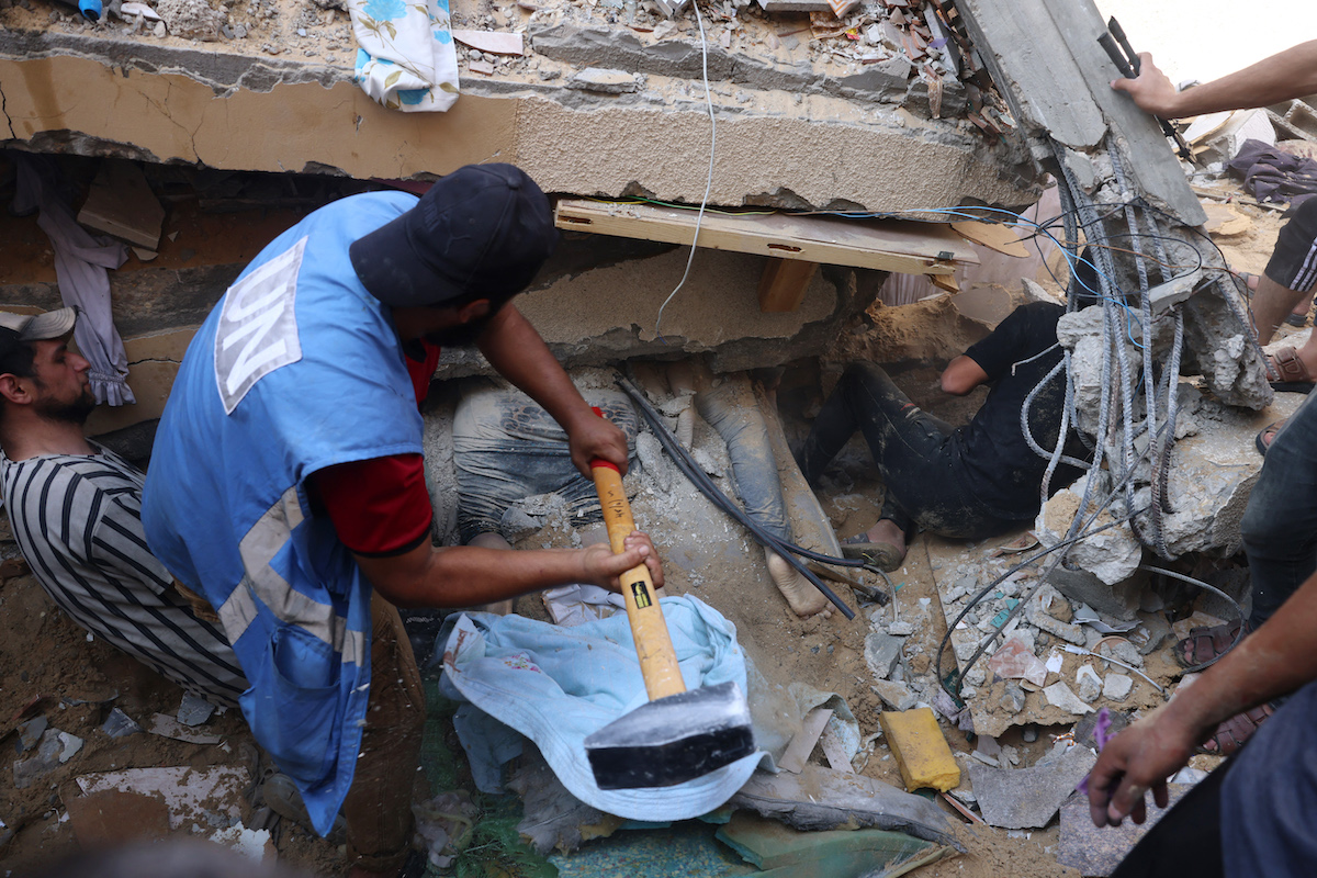 Palestinian rescuers remove the rubble of a building to recover residents in the aftermath of Israeli strikes on the Rafah refugee camp in the southern Gaza. (File/AFP)