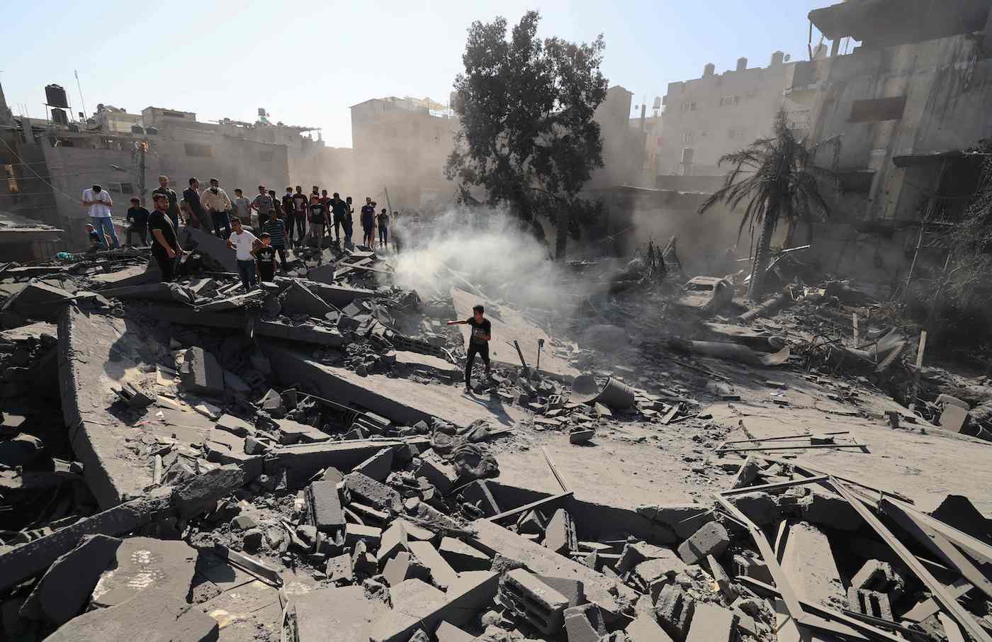 Palestinians search for survivors and the bodies in the rubble of buildings destroyed during Israeli bombardment, in Khan Yunis in southern Gaza Strip on Oct. 26, 2023. (AFP)
