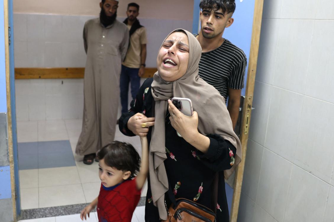 A Palestinian woman reacts as she arrives with her child to the Nasser hospital following an Israeli strike, in Khan Yunis, in the southern Gaza Strip on October 26, 2023, amid the ongoing battles between Israel and the Palestinian group Hamas. (AFP)