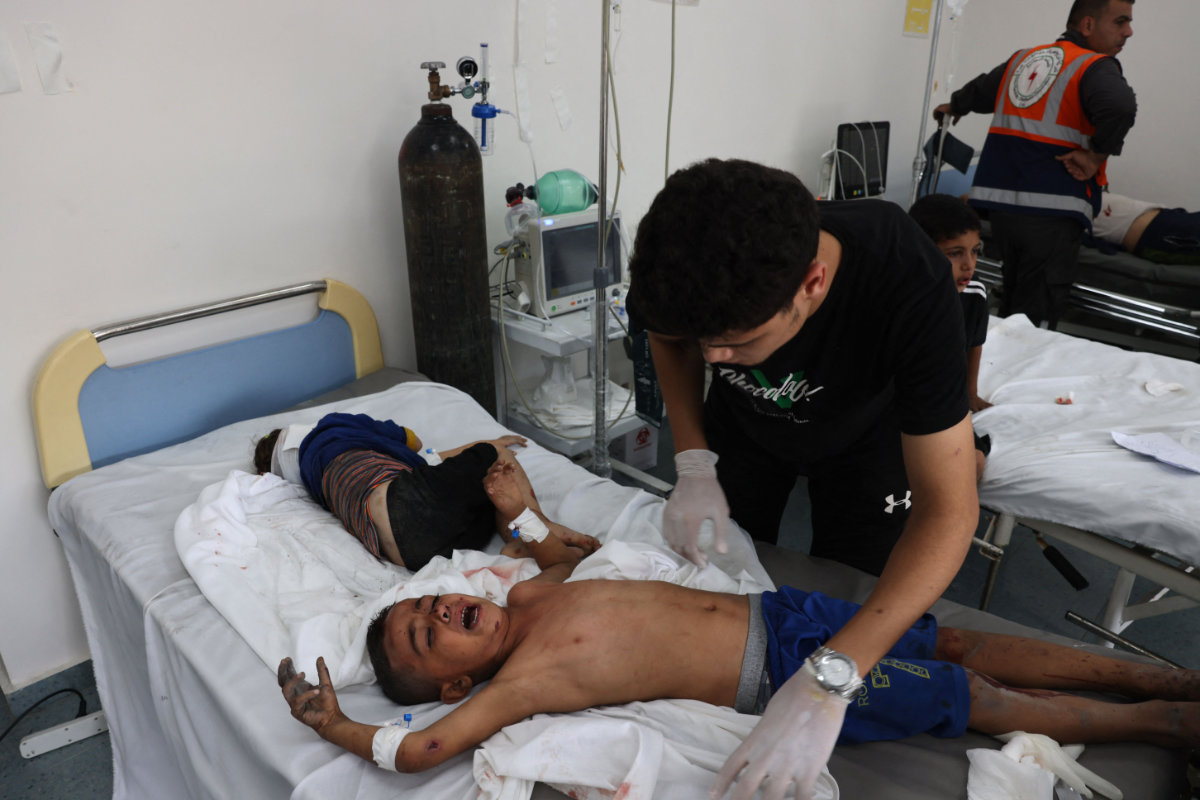A medic checks two wounded Palestinian children at a hospital in Rafah on October 23, 2023, amid the ongoing battles between Israel and the Palestinian group Hamas. (AFP)