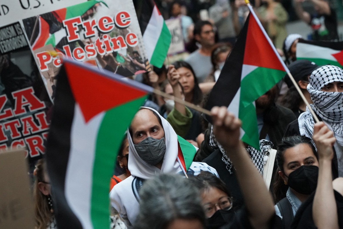 Protesters hold signs and flags during the "Flood Wall Street for Gaza" rally outside the New York Stock Exchange on October 26, 2023 in New York. (AFP)