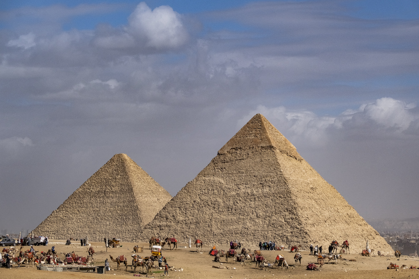 Camel guides wait near the Great Pyramid of Khufu and the Pyramid of Khafre at the Giza Pyramids necropolis on the outskirts of the Egyptian capital. (AFP)