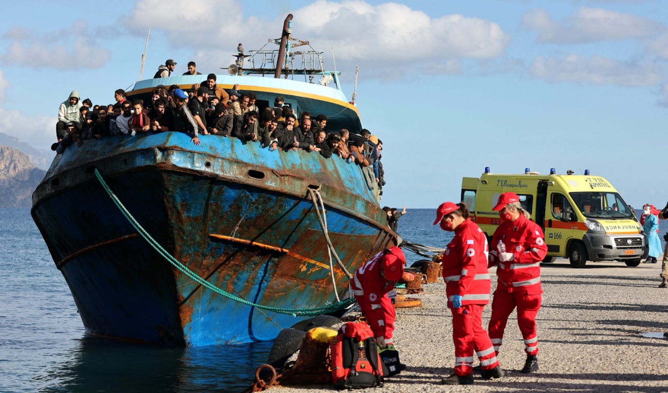 Hellenic Red Cross rescuers and health workers stand by a boat carrying some 400 refugees and migrants at the town of Paleochora, southwestern Crete island on November 22, 2022, following a rescue operation. (AFP/File)
