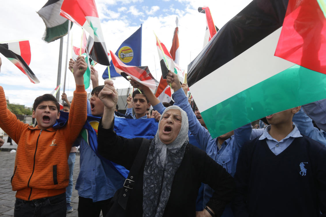 Demonstrators shout as they wave the Palestinian and Syrian flag during an anti-Israel rally in solidarity with the Palestinian people in Damascus. (File/AFP)