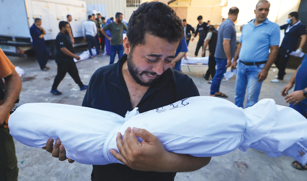 A Palestinian man mourns at the funeral service of a baby from his extended family who was killed in the Israeli bombardment in Deir Al-Balah, central Gaza Strip, on Tuesday. (AFP)