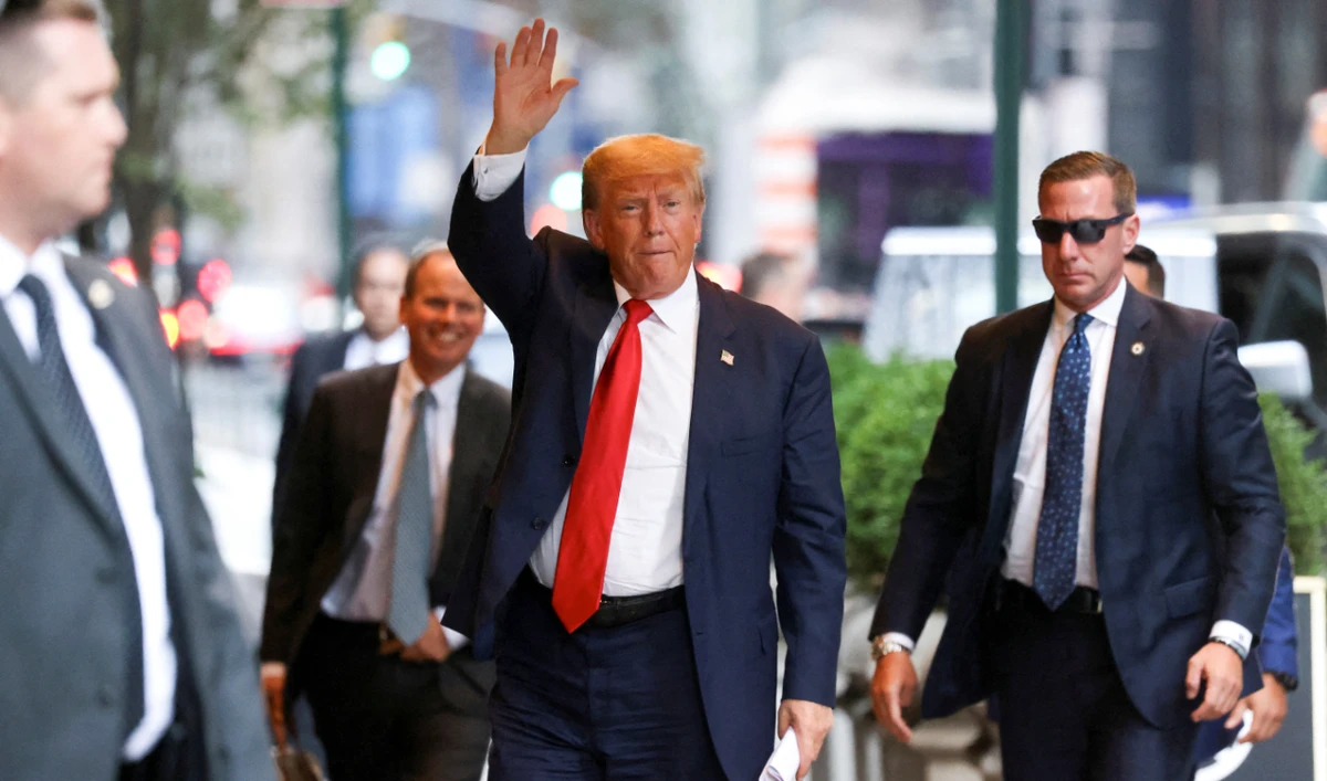 Former US President Donald Trump waves outside the Trump Tower as the trial of himself, his adult sons, the Trump Organization and others in a civil fraud case brought by state Attorney General Letitia James continues, in New York City, October 3, 2023. (Reuters)