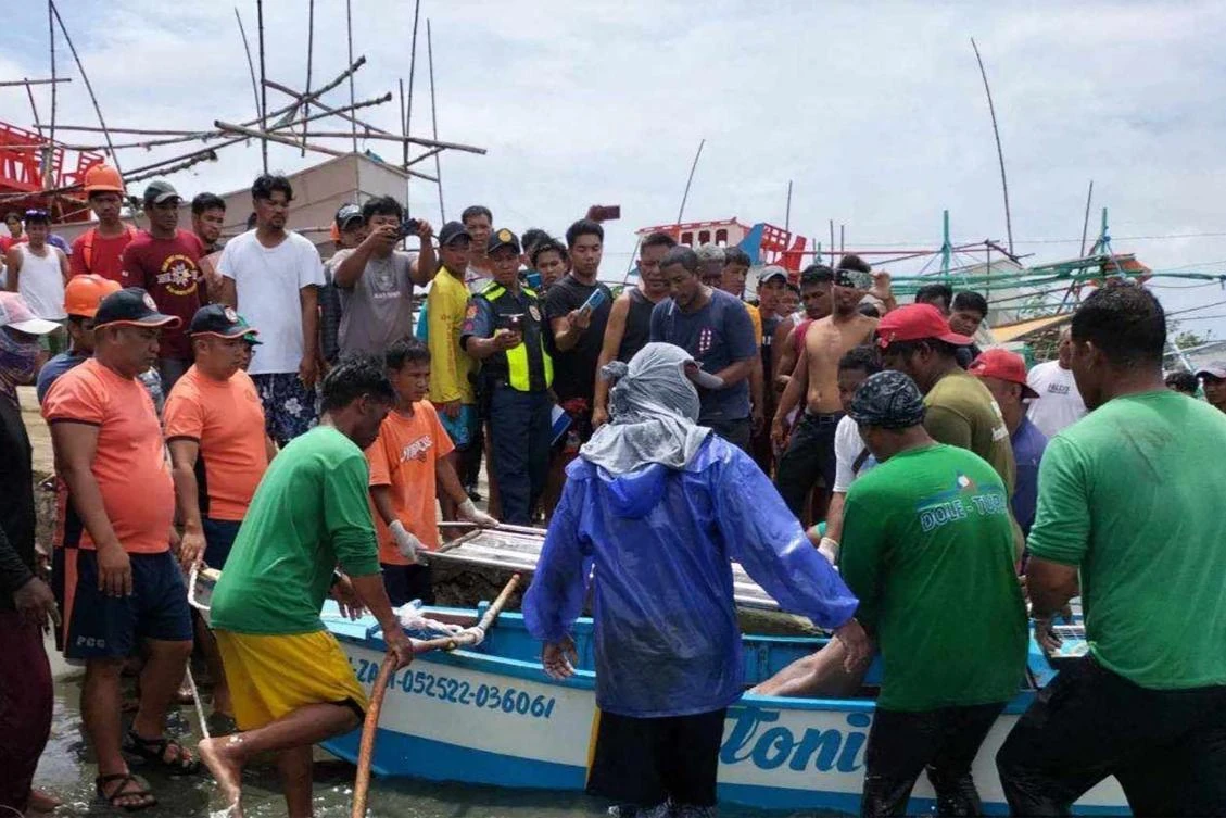 Residents retrieve the body of a crew member of a Filipino fishing boat after their boat was rammed by a foreign commercial vessel on Oct. 2, 2023 about 160 kilometers northwest of Scarborough Shoal. (Philippine Coast Guard/AFP)