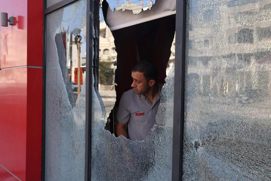 A Palestinian man inspects the damage to a store in the village of Huwara in the Israeli-occupied West Bank after an overnight attack by Israeli settlers. (AFP)