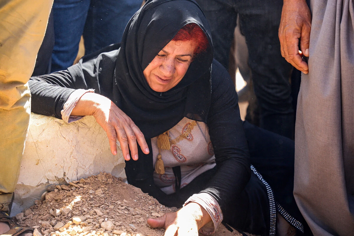 A woman mourns by the grave of one of three Kurdish counterterrorism officers killed the previous day in a strike by a drone that had reportedly originated in Turkey, during the funeral in the city of Sulaimaniyah in the autonomous Kurdish region of northern Iraq (AFP)