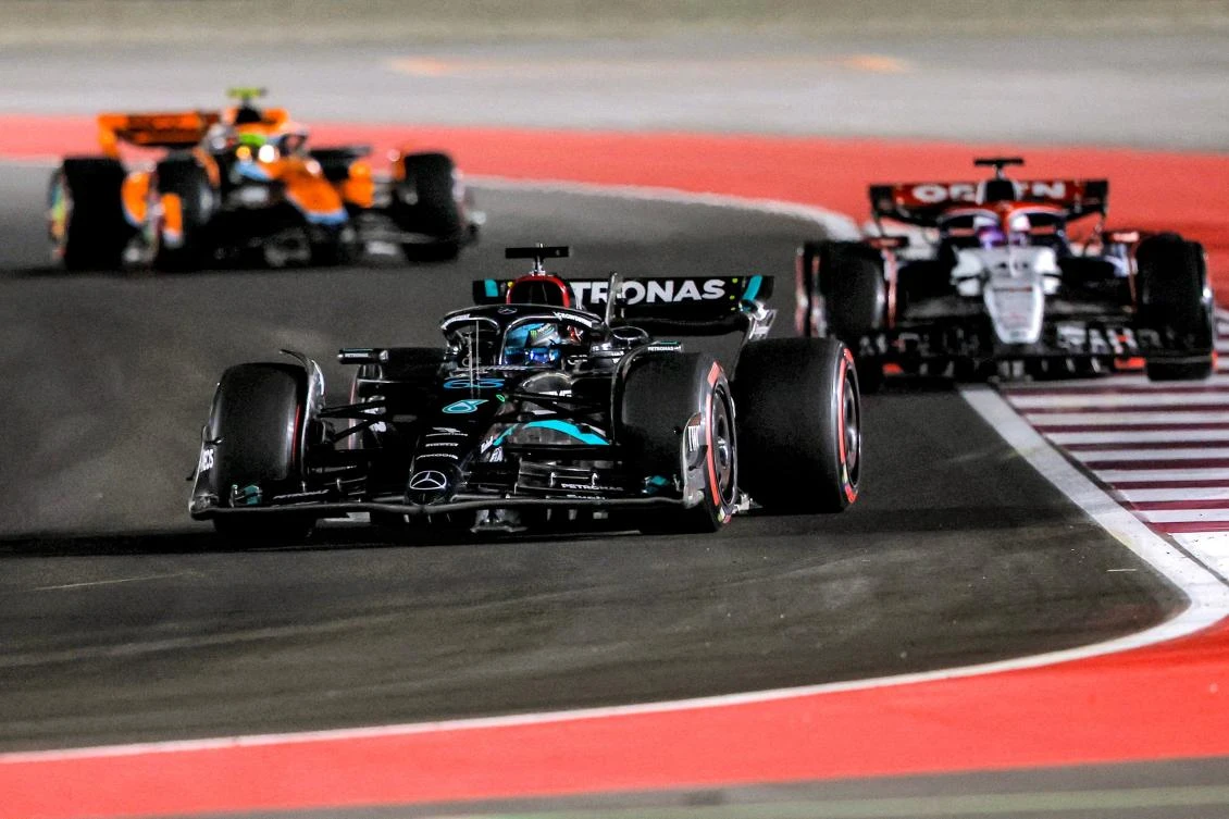 Mercedes' British driver George Russell (front) drives ahead of Alpha Tauri's New Zealander driver Liam Lawson (R) and McLaren's British driver Lando Norris during the qualifying session ahead of the Qatari Formula One Grand Prix at the Lusail International Circuit on October 6, 2023. (Photo by KARIM JAAFAR / AFP)