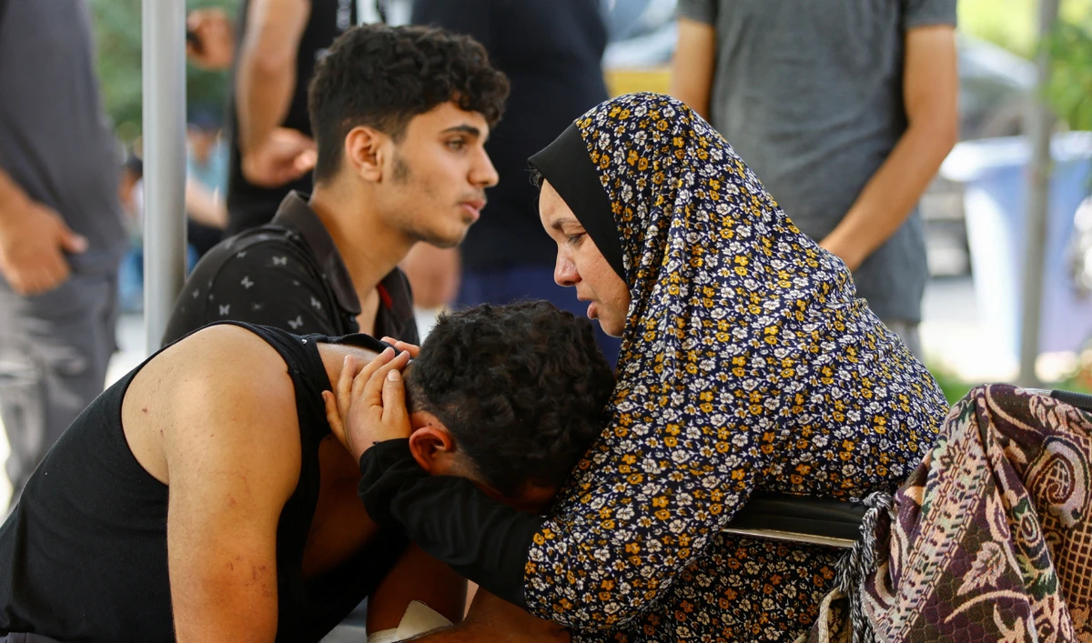 Palestinian woman Sabreen Abu Daqqa reacts before the funeral of her daughter and two sons in Khan Younis in the southern Gaza Strip on Sunday. They were killed in Israeli airstrikes. (Reuters)