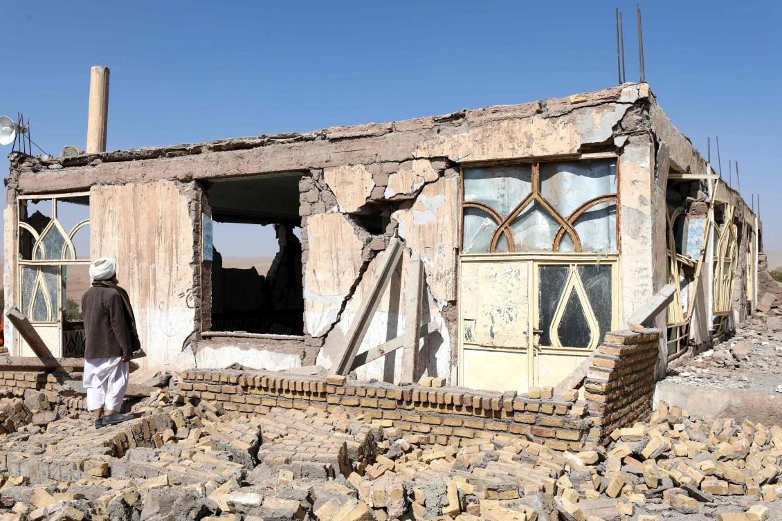 An Afghan man stands near a damaged house after the earthquakes in Sarbuland village, Zendeh Jan district of Herat province on October 8, 2023. (AFP)