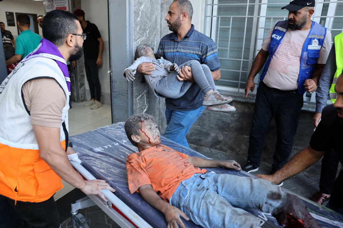 Medics transport wounded children into at al-Shifa hospital following Israeli strikes in Gaza City. (AFP)