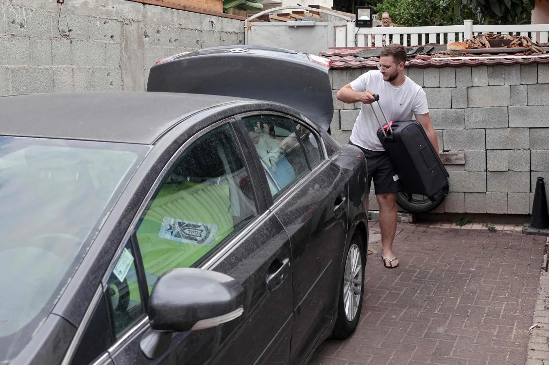 An Israeli man evacuates his house in the northern city of Shlomi on the Israeli-Lebanon border, on Oct. 11, 2023. (AFP)