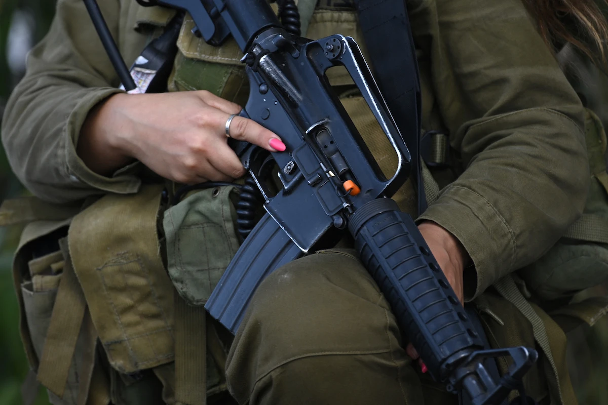 An Israeli soldier stands guard in Kibbutz Beeri near the border with the Gaza Strip on October 15, 2023. (AFP)