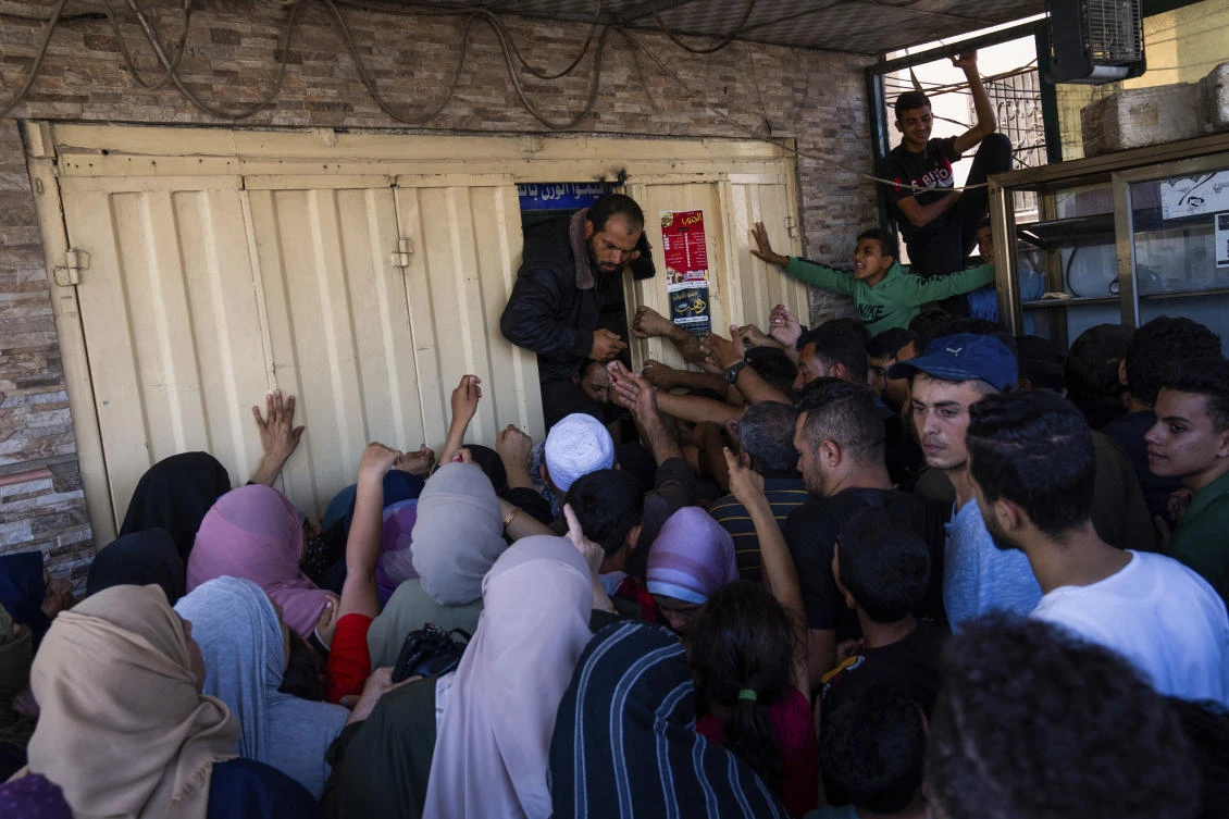 Palestinians attempt to buy bread from a bakery, Khan Younis, Gaza Strip, Oct. 15, 2023. (AP Photo)