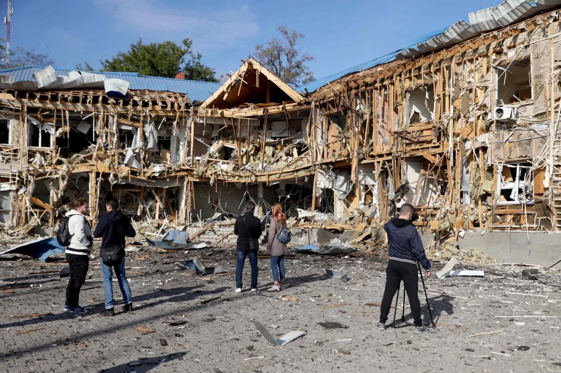People and media look at a yacht club damaged as a result of falling remains of a Russian drone shot down in Odesa on October 17, 2023, amid Russian invasion in Ukraine. (AFP)