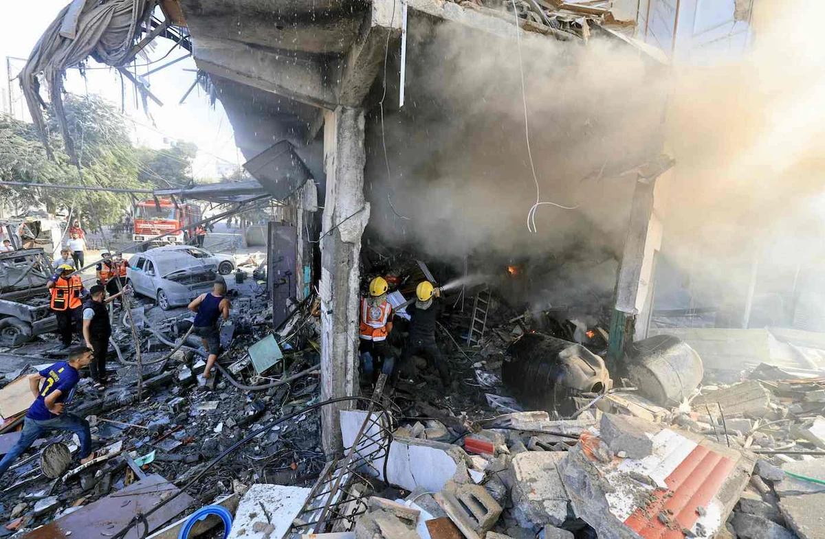 Palestinian rescuers douse a fire at the scene of an Israeli strike in Khan Yunis in the southern Gaza Strip on October 17, 2023. (AFP)