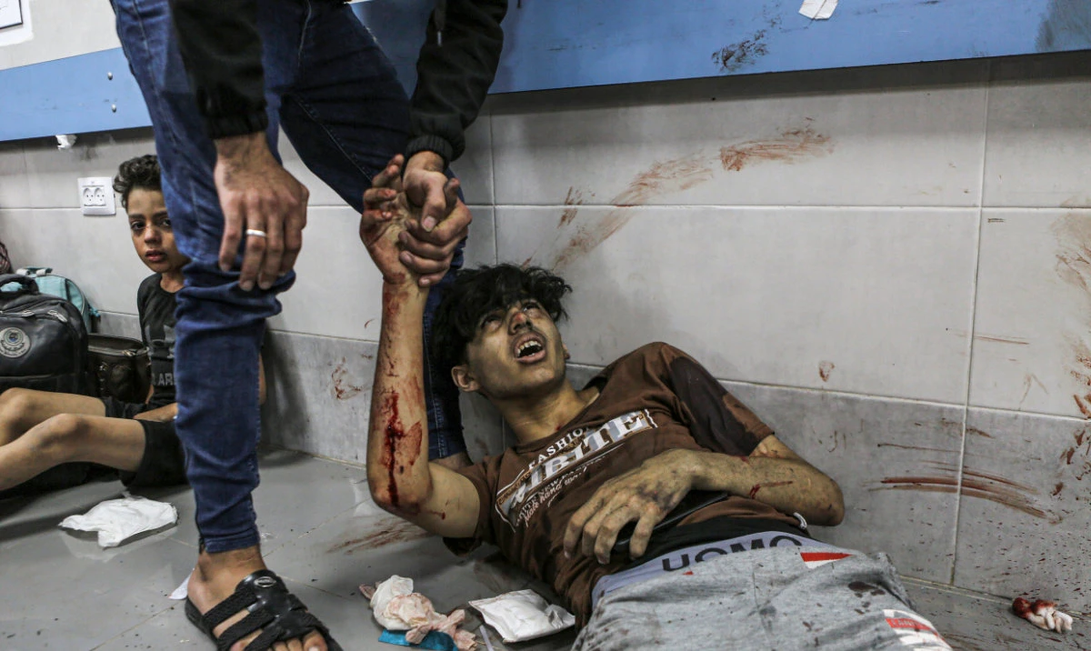 Wounded Palestinians lie on the floor in Al-Shifa Hospital in Gaza City, central Gaza Strip, after arriving from Al-Ahli Hospital following an explosion there, Tuesday, Oct. 17, 2023. (AP)
