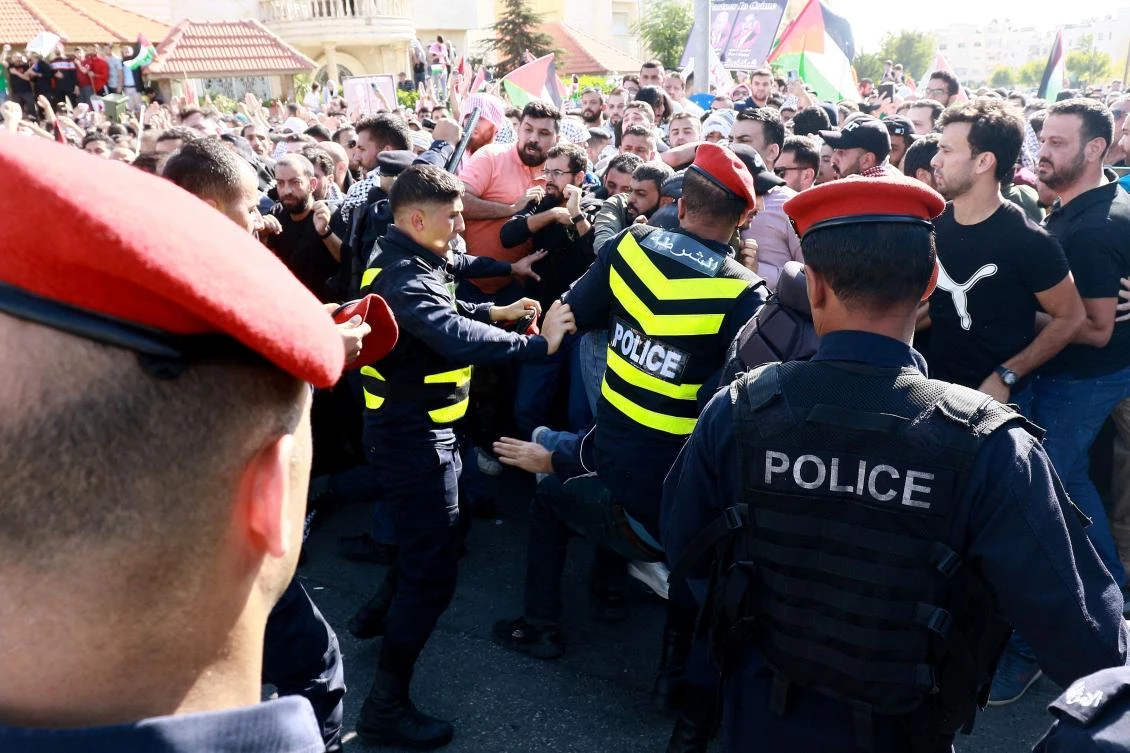 Protesters scuffle with Jordanian police near the Israeli Embassy in Amman on October 18, 2023, as they demonstrate against the killing of hundreds of Palestinians following a strike on a hospital in the Gaza Strip. (AFP)