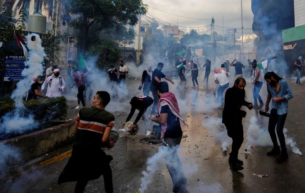Riot police use tear gas against protesters during a demonstration, in solidarity with the Palestinian people in Gaza, near the US embassy in Awkar, Beirut, Lebanon, Wednesday, Oct. 18, 2023. (AP Photo)