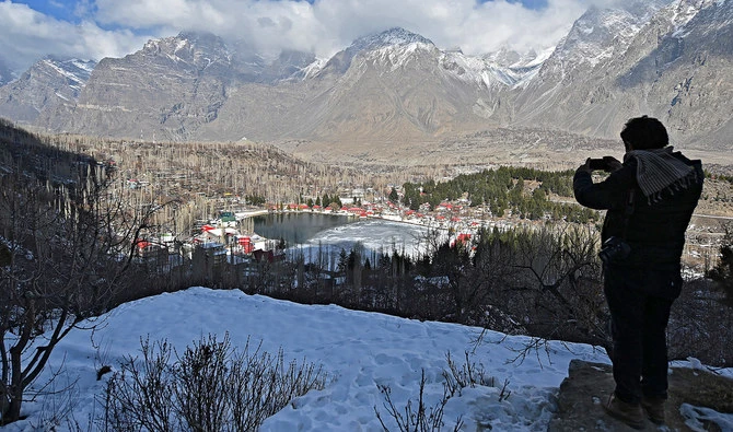 A tourist takes pictures of the Lower Kachura Lake at the Shangrila Resort, about 6 Km from Skardu on January 24, 2021. (AFP/File)