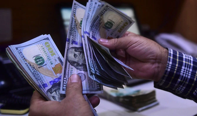 A dealer counts US dollars at a money exchange market in Karachi on March 2, 2023. (AFP/File)