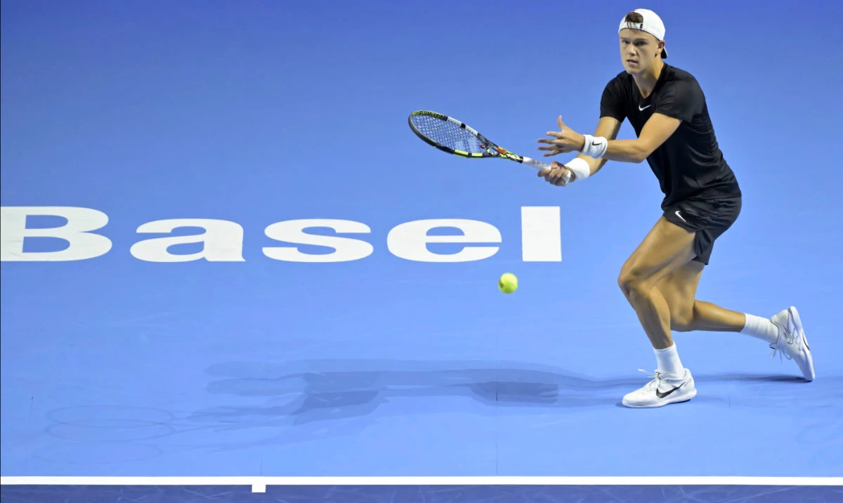 Denmark's Holger Rune returns a ball to Serbia's Miomir Kecmanovic during their first round match at the Swiss Indoors tennis tournament at the St. Jakobshalle in Basel, Switzerland, on Tuesday. (AP)