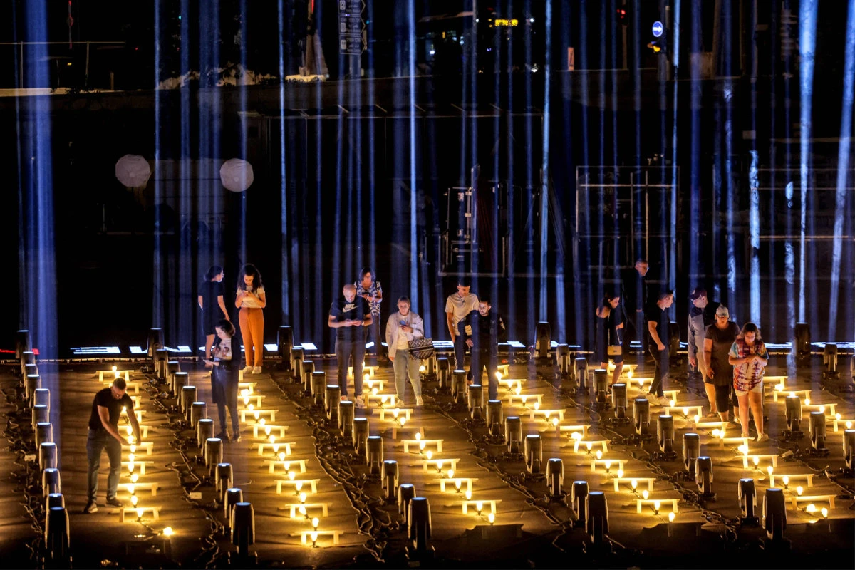 Israelis seek comfort in an installation consisting of 224 pillars of light erected by the Jerusalem municipality outside Teddy Stadium as a tribute for hostages abducted by Palestinian militants during the October 7 attack and currently held in the Gaza Strip. (AFP)