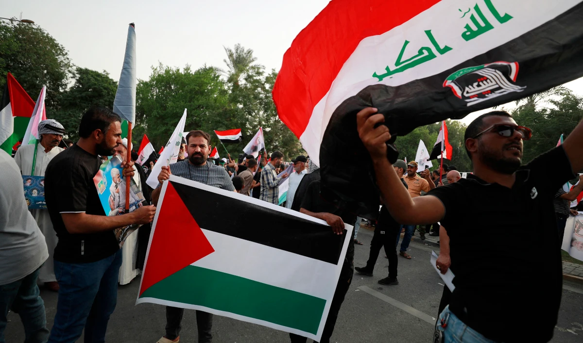 Iraqis carry placards and wave the Palestinian flag during a protest in Baghdad, October 20, 2023, to express their support of the Palestinian people amid the ongoing battles between Israel and Palestinian groups. (AFP)