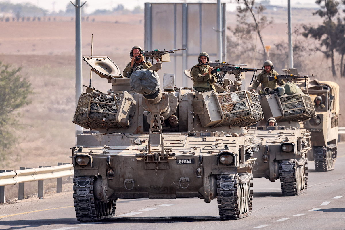 Israeli army self-propelled artillery howitzers move in a convoy with other vehicles along a road by the border with the Gaza Strip in southern Israel. (File/AFP)