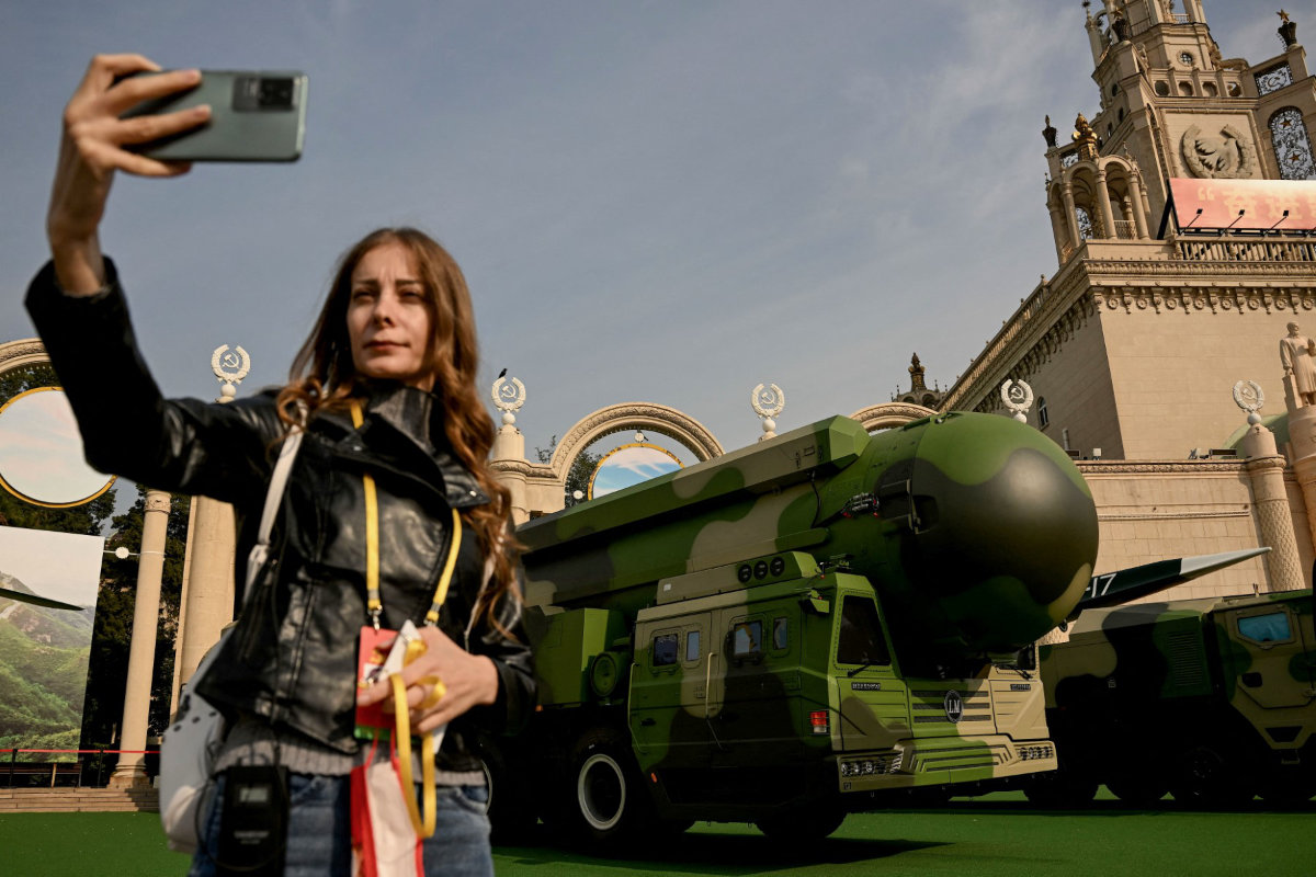 A tourist takes a selfie in front of the Dongfeng-41 (DF-41), an intercontinental ballistic missile on display, at the Beijing Exhibition Center, in Beijing on October 12, 2022. (AFP/File)