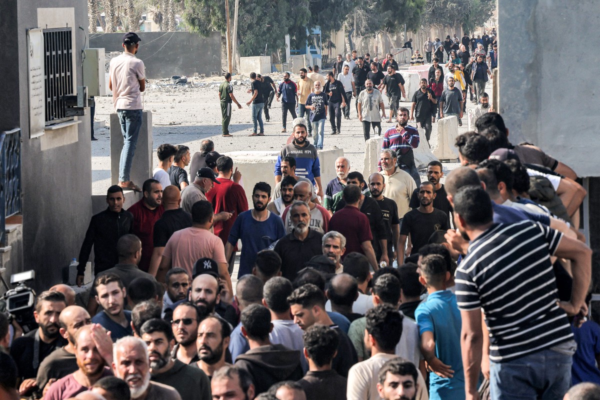 Palestinian workers, who were stranded in Israel since the October 7 attacks, cross back into the Gaza Strip at the Kerem Shalom commercial border crossing with Israel (AFP)