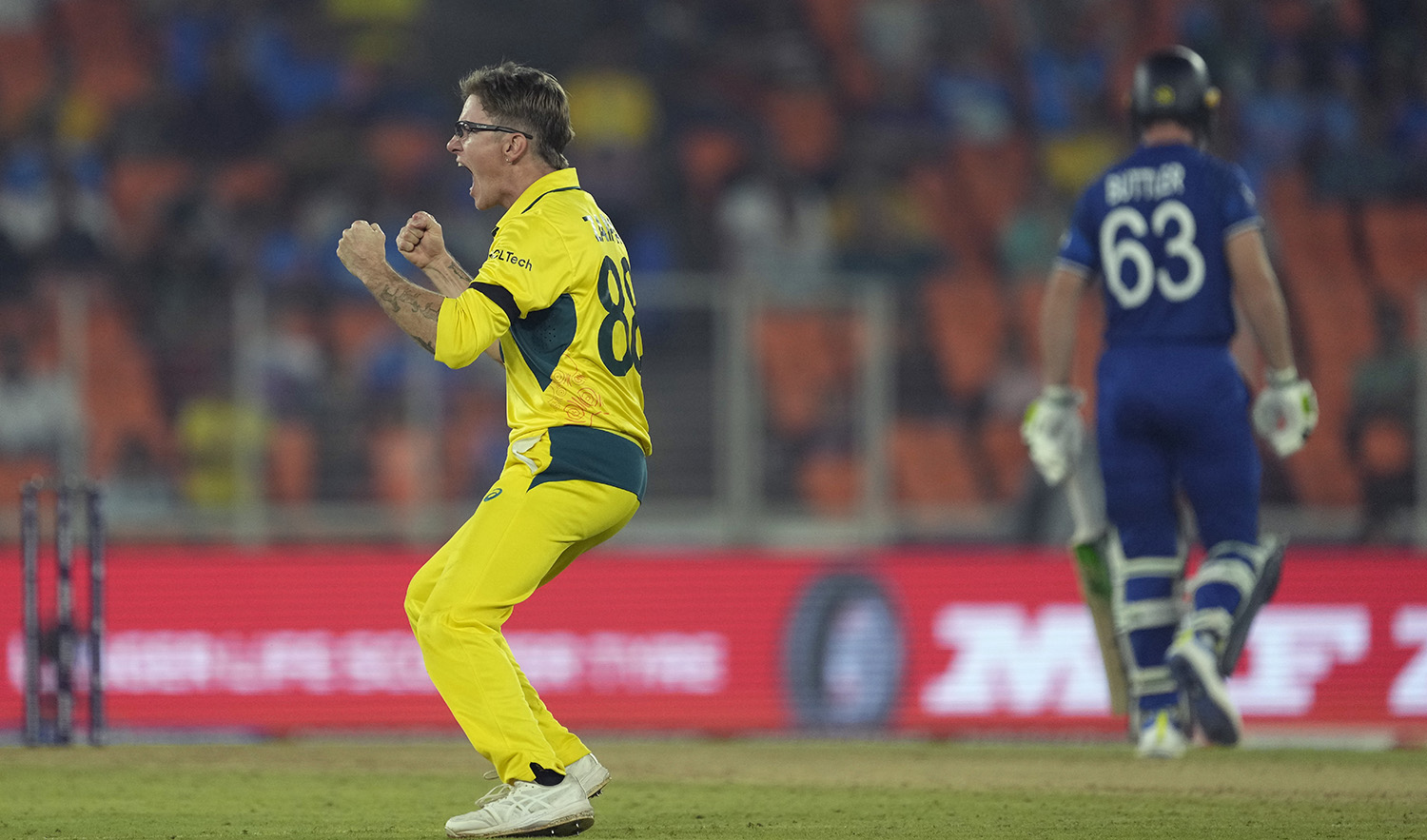 Australia's Adam Zampa celebrates the wicket of England's captain Jos Buttler, right, leaving the field, during the ICC Men's Cricket World Cup match between Australia and England in Ahmedabad, India, on November 4, 2023. (AP)