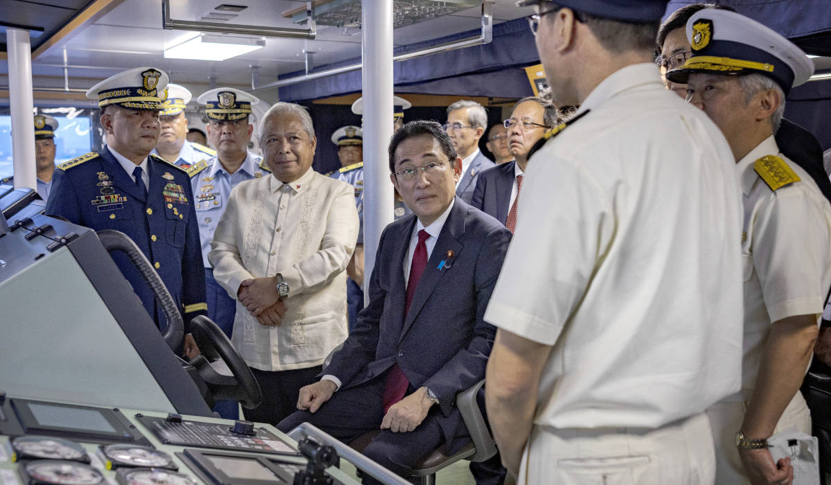 Japan's Prime Minister Fumio Kishida, center, sits on the bridge of the BRP Teresa Magbanua ship at the Philippine Coast Guard headquarters on Saturday Nov. 4, 2023 in Manila, Philippines. (AP)