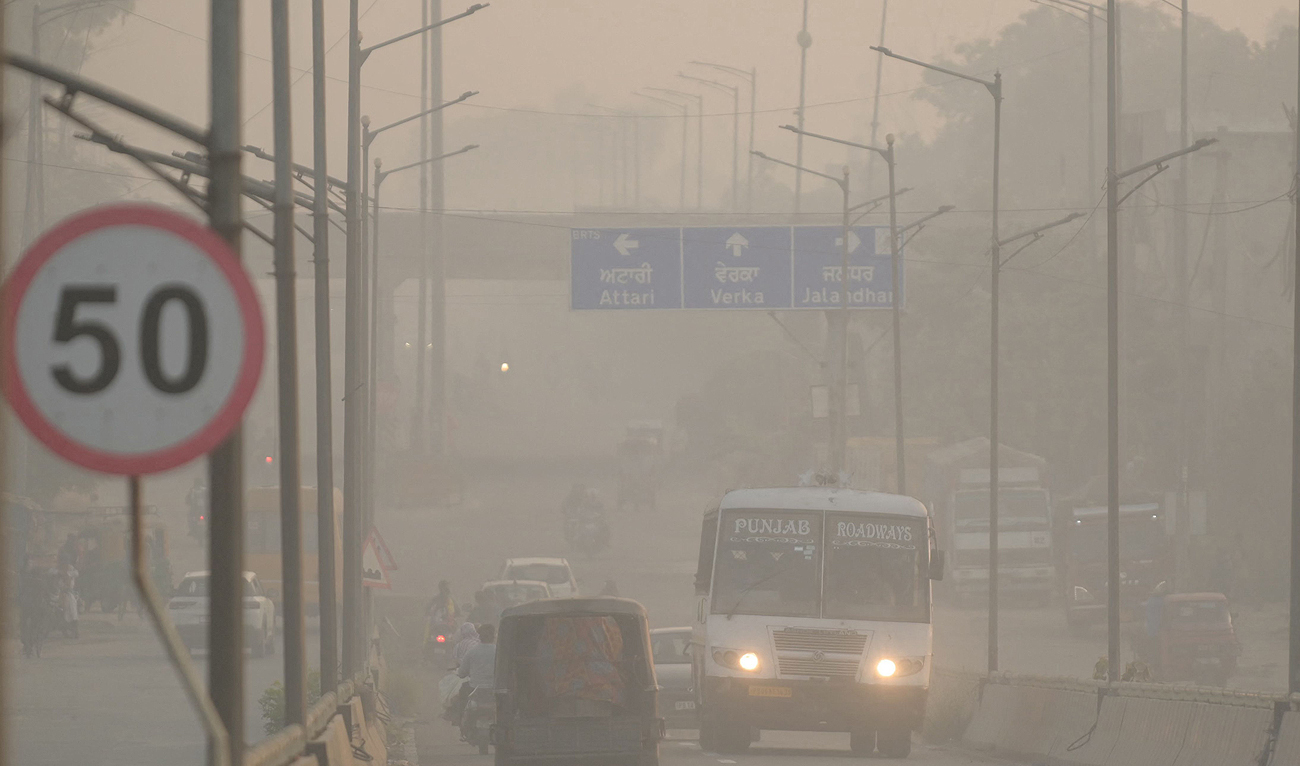 Commuters make their way along a road amid heavy smoggy conditions on the outskirts of Amritsar on November 5, 2023. (AFP)