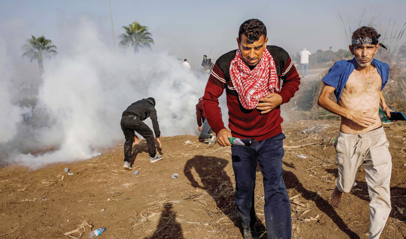 Protestors run amid the tear gas fired by Turkish anti-riot police during a demonstration near the Incirlik Air Base — housing US forces — in Adana. (AFP)