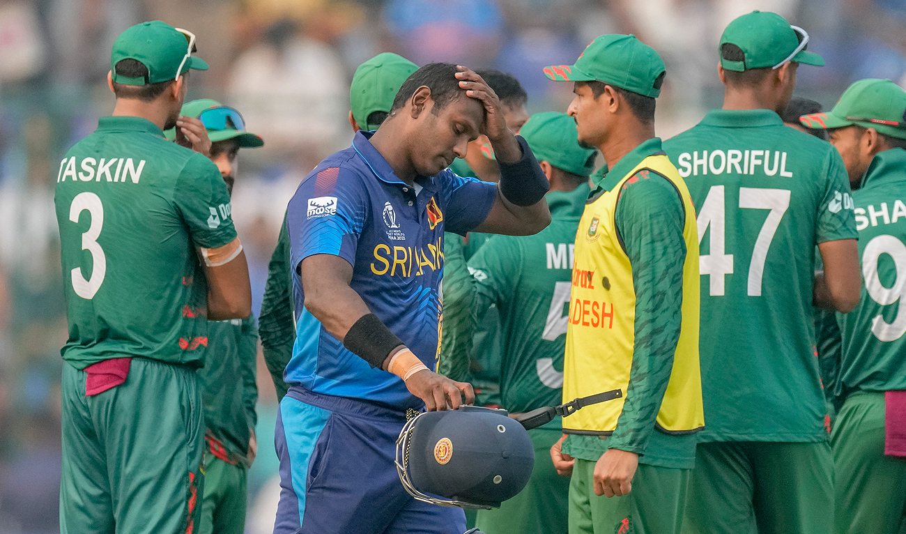 Sri Lanka's Angelo Mathews, foreground walks off the field after he was declared timed out during the ICC Men's Cricket World Cup match between Bangladesh and Sri Lanka in New Delhi, India, Monday, Nov. 6, 2023. (AP)