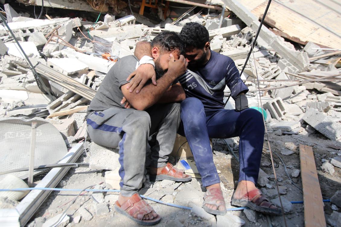 Palestinians mourn as they sit on the rubble of a building in Gaza City's Shati refugee camp on November 6, 2023, amid ongoing battles between Israel and the Palestinian Hamas movement. (AFP)