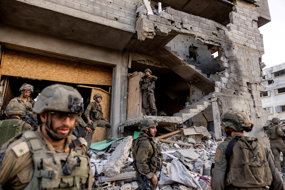 Israeli soldiers stand amid rubble, during the ongoing ground invasion against Palestinian Islamist group Hamas in the northern Gaza Strip, November 8, 2023. (Reuters)