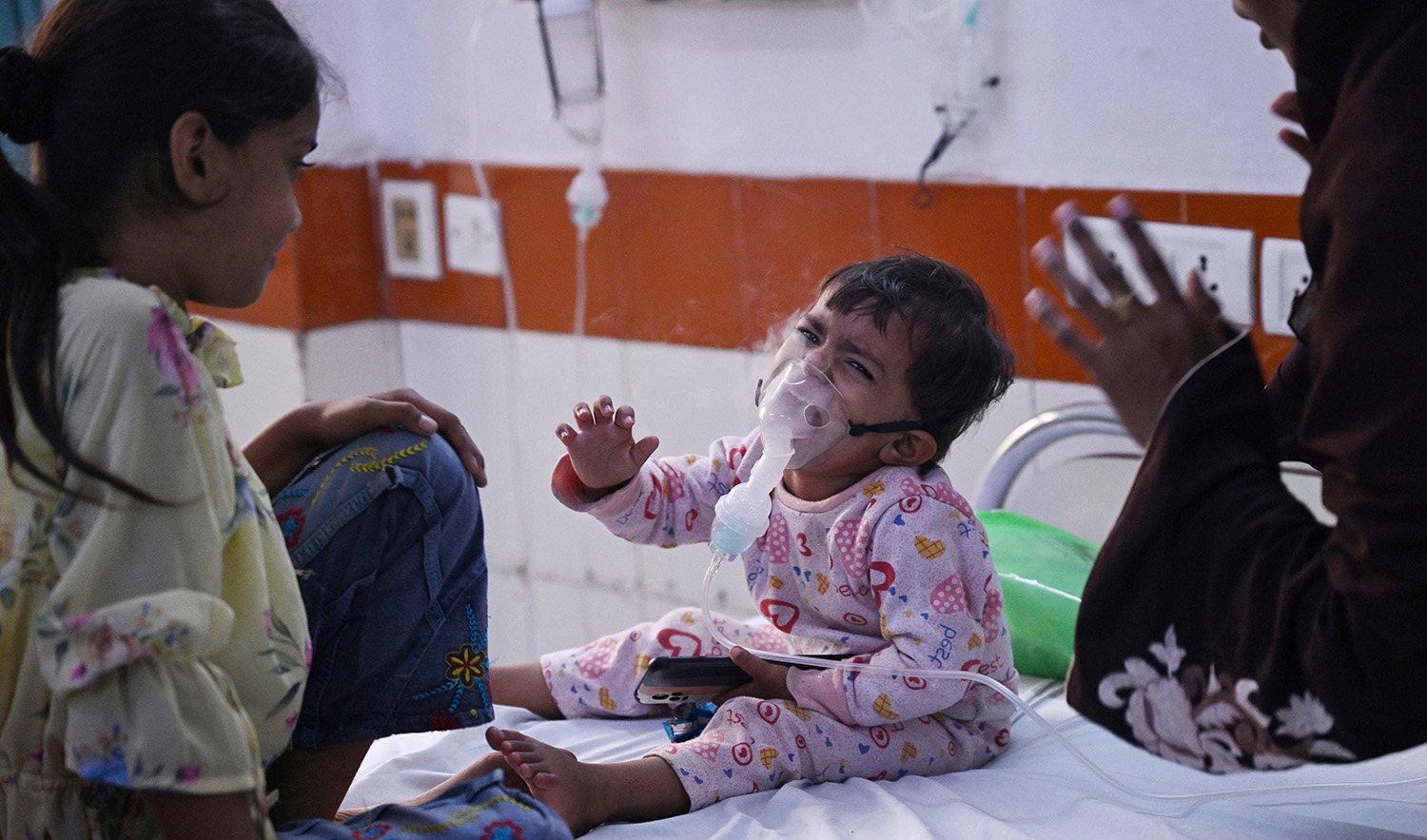 A child reacts as he breathes with the help of a nebulizer at the emergency ward of the government-run Chacha Nehru Bal Chikitsalaya children hospital in New Delhi on November 7, 2023. (AFP)