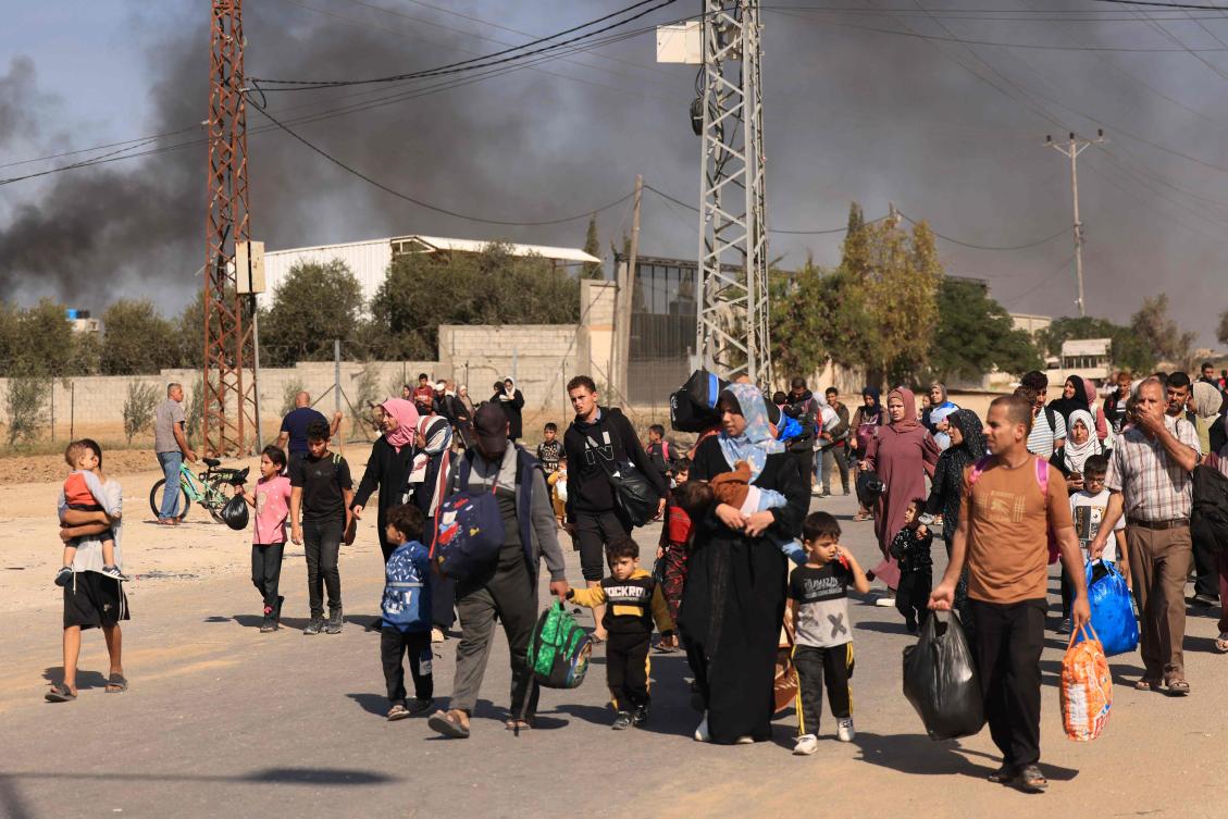 Palestinians families fleeing Gaza City and other parts of northern Gaza toward the southern areas, walk along a road on Nov. 10, 2023. (AFP)